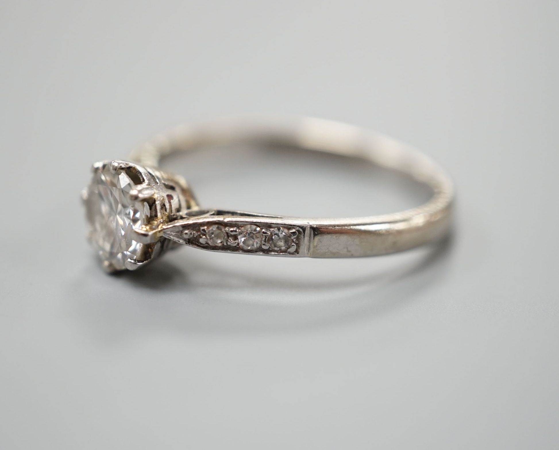An 18ct and plat, single stone diamond ring, with diamond set shoulders, size O, gross weight 2.9 grams